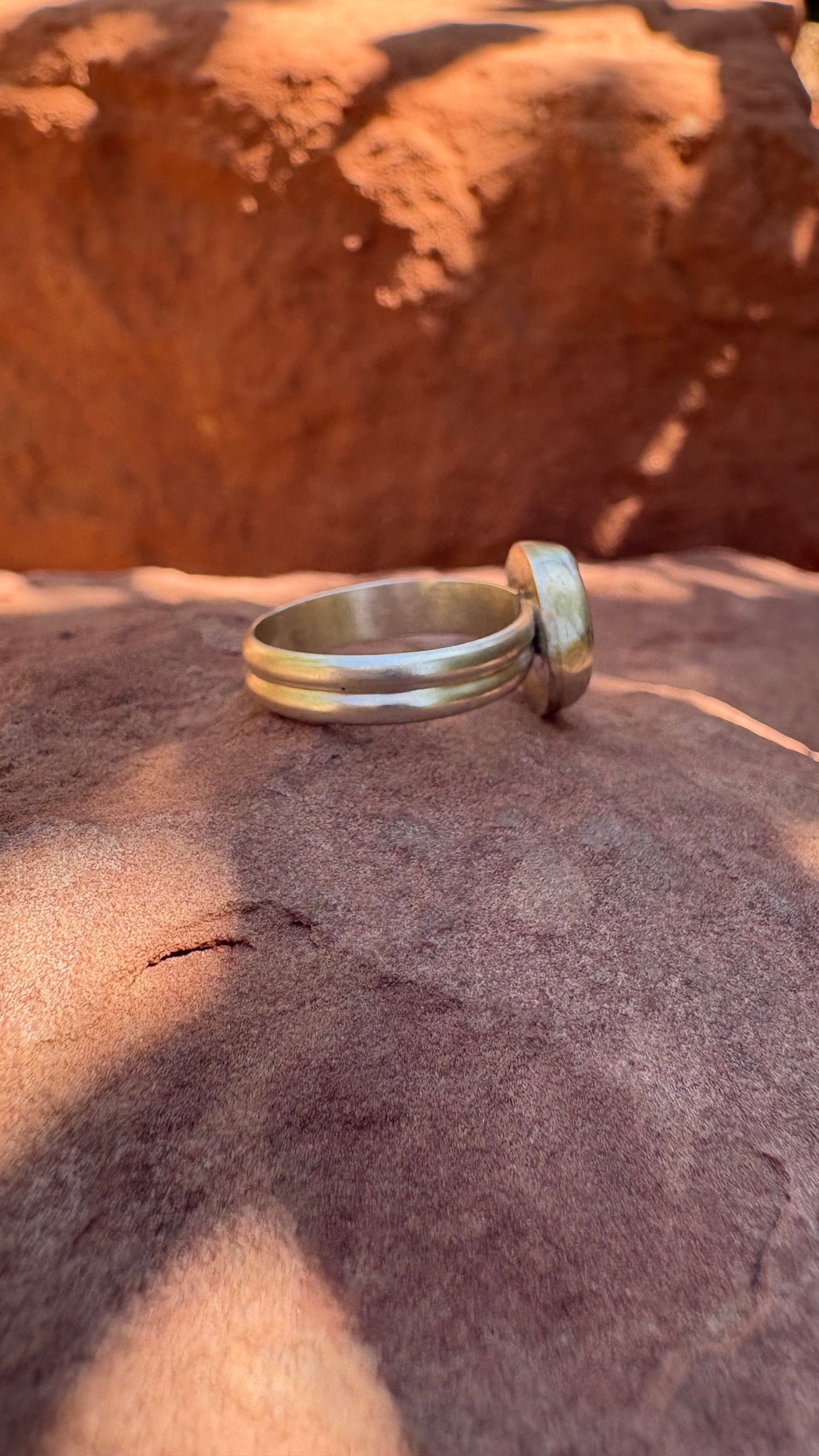 Silver ring on a textured stone surface