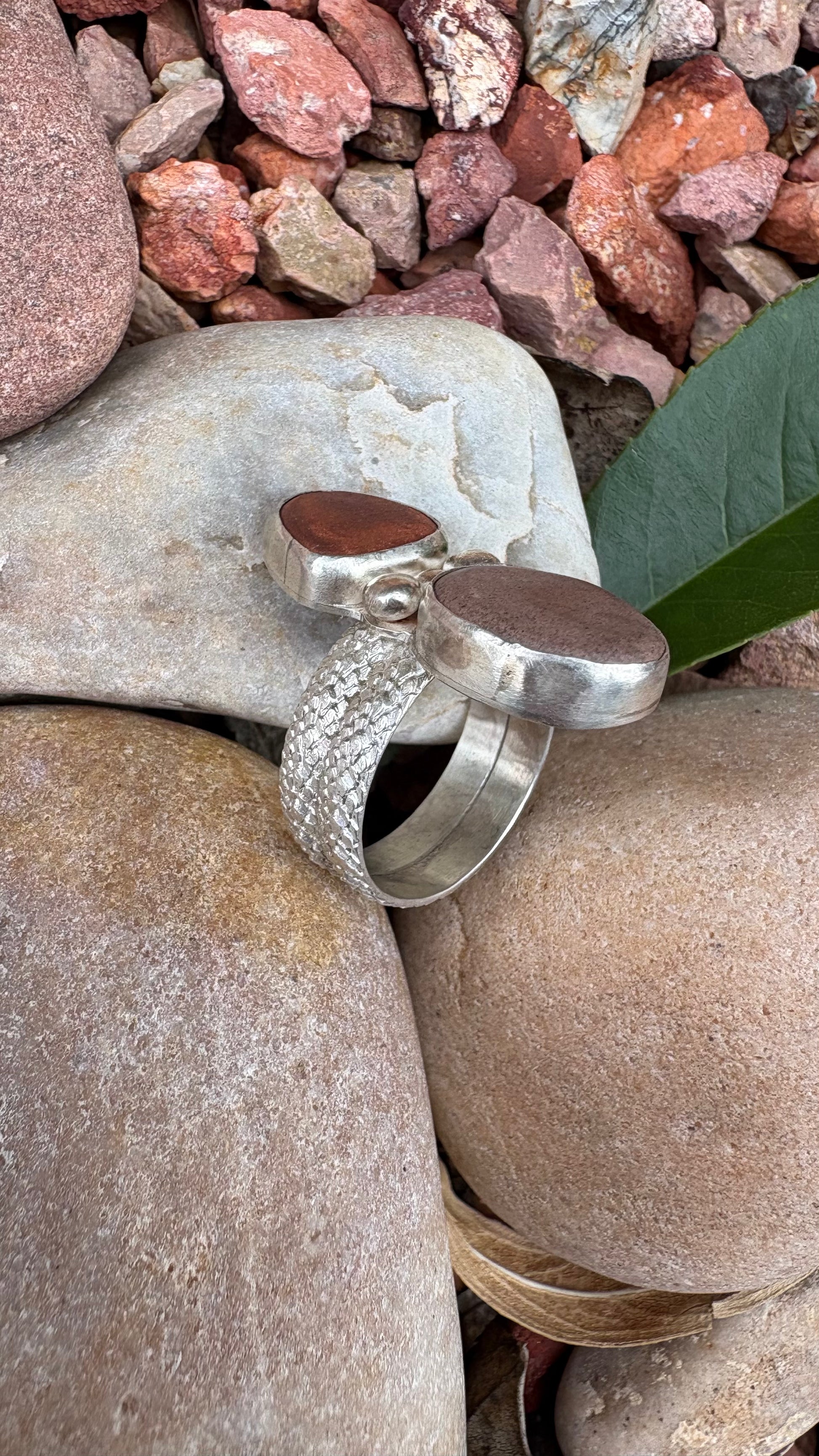 Silver ring with brown stones on a rock background