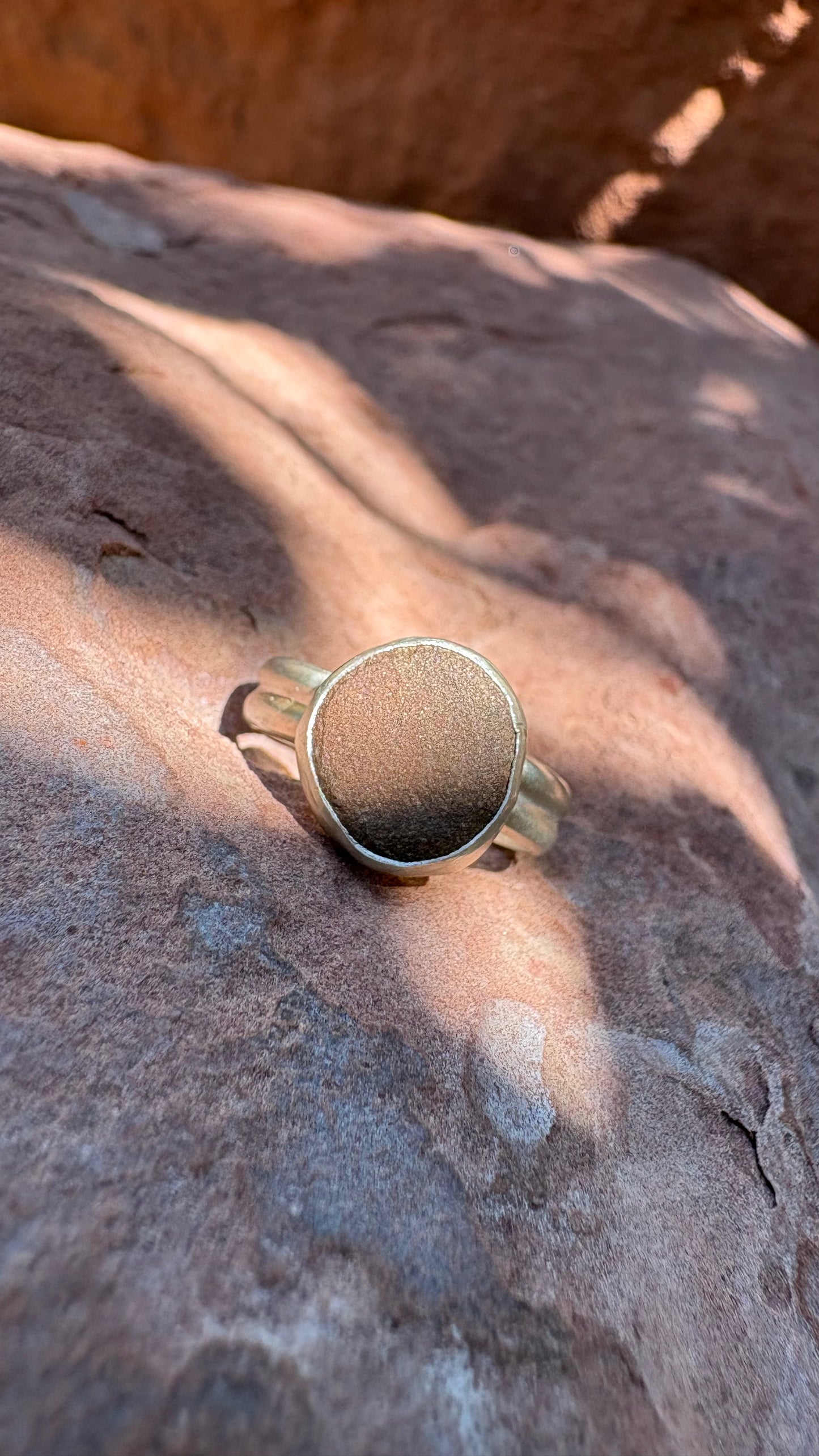 Sterling Silver ring on a sandy rust colored stone surface